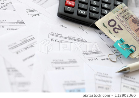 Polish zloty money PLN, calculator and pen on big amount of polish PIT, CIT and VAT tax forms close up. Accounting, bureaucracy and taxpayers routine in Poland Polish zloty money PLN, calculator and pen on big amount of polish PIT, CIT and VAT tax forms close up. Accounting, bureaucracy and taxpayers routine in Poland 112902360