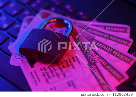 Permanent resident green card for US DV-lottery with small padlock on computer keyboard close up 112902439