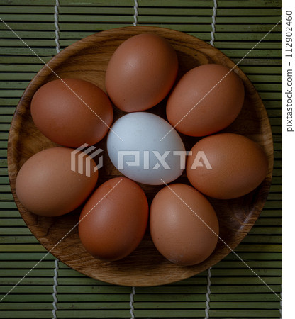 Fresh chicken eggs in wooden plate on the table, selective focus Fresh chicken eggs in wooden plate on the table, selective focus 112902460