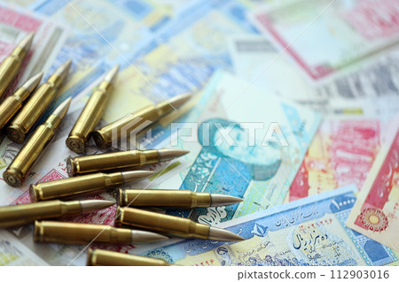 Many bullets and iranian rials money bills close up. Concept of terrorism funding or financial operations to support war in Iran Many bullets and iranian rials money bills close up. Concept of terrorism funding or financial operations to support war in Iran 112903016