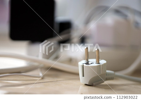 Overloaded power boards. Power strips with different electrical plugs on white floor. Concept of risk danger overloaded current electrical 112903022