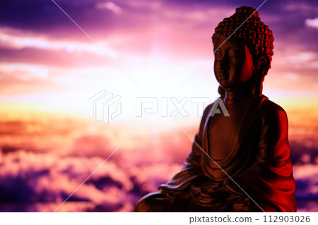 Buddha Purnima and Vesak day concept, Buddha statue with low key light against beautiful and colorful background close up. Meditation Buddha Purnima and Vesak day concept, Buddha statue with low key light against beautiful and colorful background close up. Meditation 112903026