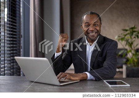 Portrait of mature experienced man businessman winner, senior african american boss joyful looking at camera, holding hands up in triumph gesture, celebrating successful achievement results. Portrait of mature experienced man businessman winner, senior african american boss joyful looking at camera, holding hands up in triumph gesture, celebrating successful achievement results. 112903334