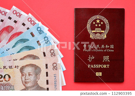Red passport of People Republic of China and chinese yuan money bills. PRC chinese passport on bright background close up Red passport of People Republic of China and chinese yuan money bills. PRC chinese passport on bright background close up 112903395