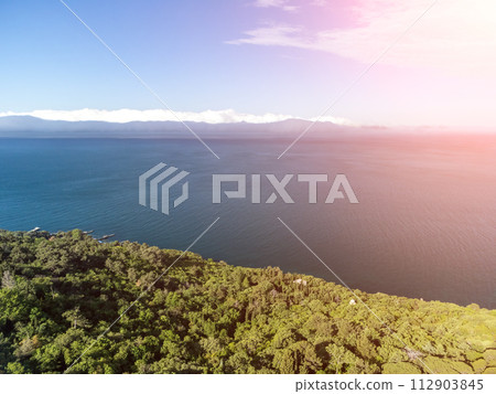 Aerial sea clouds. Panoramic view of seascape with crystal clear azure sea. Yachts in a beautiful lagoon on backdrop of rocks. The concept of an ideal destination for summer travel and vacation. Aerial sea clouds. Panoramic view of seascape with crystal clear azure sea. Yachts in a beautiful lagoon on backdrop of rocks. The concept of an ideal destination for summer travel and vacation. 112903845