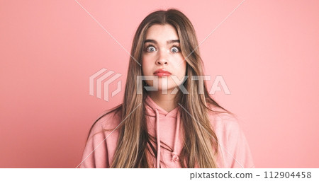 Amazed female model with wide open eyes over pink background 112904458