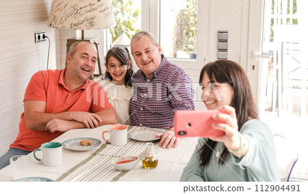 Gay couple with granddaughter and daughter taking smartphone selfie 112904491