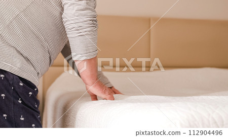 Gay couple getting the sheets right and making the bed in the morning Gay couple getting the sheets right and making the bed in the morning 112904496