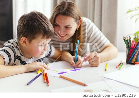 Mother and son drawing together with colorful pencils. 112905239