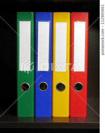Four blank binders in green, blue, yellow and red colors 112905661