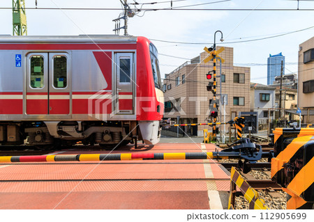 鐵路道口屏障和通過鐵路道口的通勤列車 鐵路道口屏障和通過鐵路道口的通勤列車 112905699