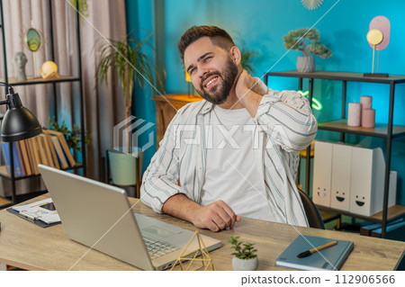 Business man freelancer overworking suffers from spine neck muscle pain at home office workplace 112906566