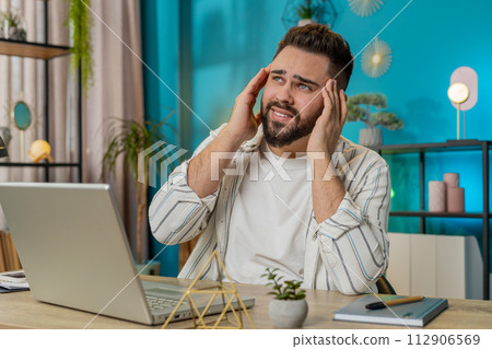 Tired ill businessman suffering from headache problem tension and migraine stress at home office 112906569