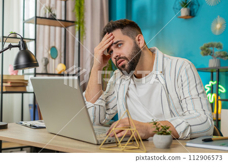 Sad frustrated pensive annoyed man suffers from unfair situation bankruptcy stress at home office Sad frustrated pensive annoyed man suffers from unfair situation bankruptcy stress at home office 112906573