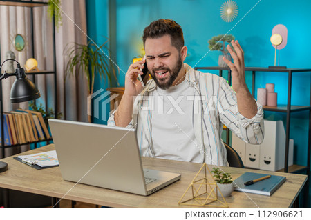 Furious annoyed angry businessman freelancer engage in heated phone quarrel conversations at office 112906621