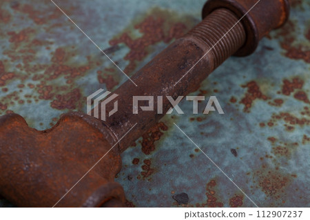 Rusty plumb tube on rusty metal wall 112907237