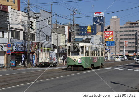 [Number, logo and driver blurred] Hakodate City Tram 810 type bamboo color Hakodate City Tram color revival car 112907352