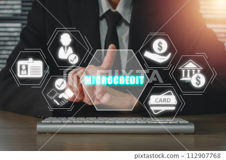 Microcredit concept, Businessman working on office desk and hand touching microcredit icon on virtual screen. Microcredit concept, Businessman working on office desk and hand touching microcredit icon on virtual screen. 112907768