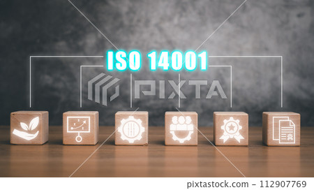 Iso 14001 concept, Wooden block on desk with iso 14001 icon on virtual screen. Iso 14001 concept, Wooden block on desk with iso 14001 icon on virtual screen. 112907769