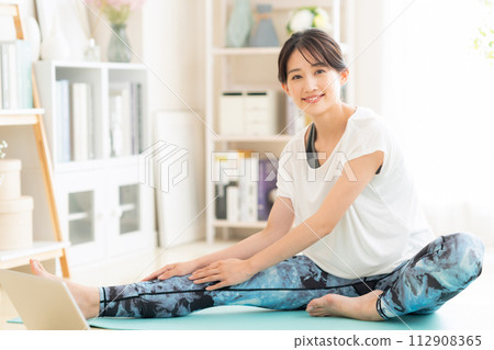Young woman doing yoga in the living room Young woman doing yoga in the living room 112908365