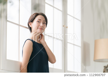 美麗的中年婦女站在窗邊 美麗的中年婦女站在窗邊 112908707