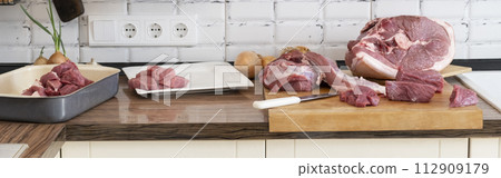 Different tipes of meat, cutting fresh raw meat on board in white kitchen. Preparing pork meat, cooking, banner. 112909179