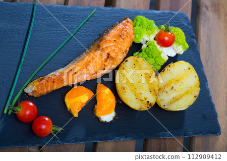 Grilled salmon with egg yolk and vegetables Grilled salmon with egg yolk and vegetables 112909412