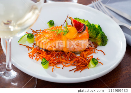Deliciously steak of fried salmon with smoked carrots, broccoli and fig 112909483
