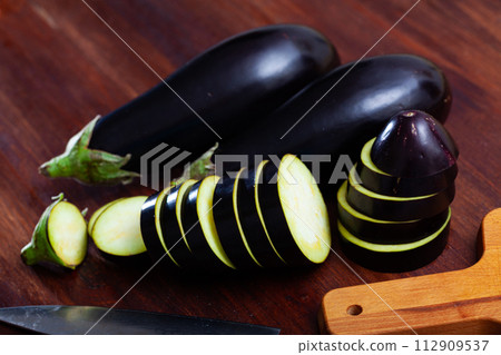Sliced aubergine on wooden table Sliced aubergine on wooden table 112909537