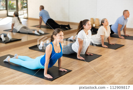 Woman performing back bending asana Urdhva Mukha Shvanasana 112909817