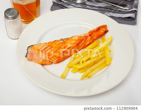 Tasty grilled salmon served with french fries 112909904