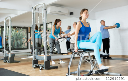 Woman doing exercises on wunda chair in pilates studio Woman doing exercises on wunda chair in pilates studio 112910291