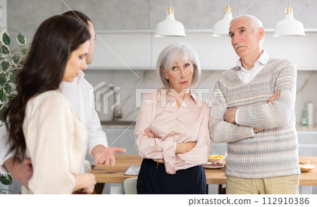 Young guy introducing his girlfriend to his discontented parents at home 112910386