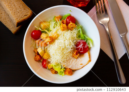 Chicken Caesar salad with tomatoes and cheese 112910643