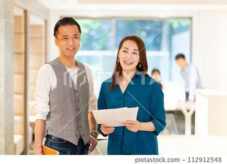 Middle-aged men and women working in the office Middle-aged men and women working in the office 112912548