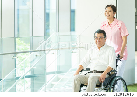 Senior in wheelchair and young female caregiver 112912610