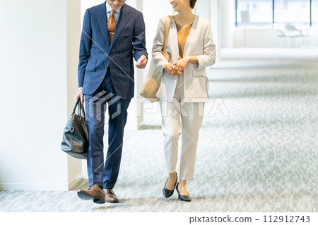Middle-aged business person walking in the office hallway Middle-aged business person walking in the office hallway 112912743