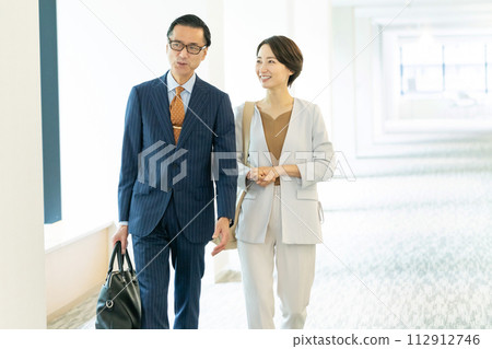 走在辦公室走廊的中年商務人士 112912746