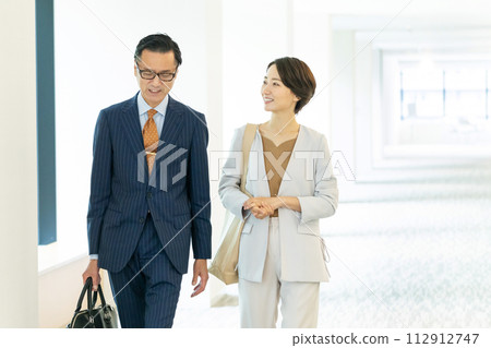 走在辦公室走廊的中年商務人士 112912747