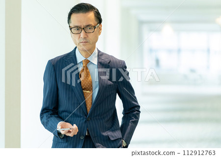 站在辦公室走廊上的一位老人的肖像 站在辦公室走廊上的一位老人的肖像 112912763