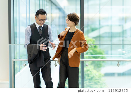 Businessmen having a meeting in the office hallway 112912855