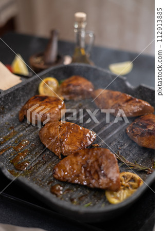 marinated pieces of Organic Tuna Steak frying on a hot grill pan 112913885