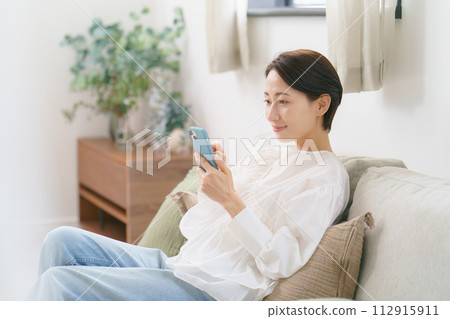 Profile of a middle-aged woman looking at a smartphone Profile of a middle-aged woman looking at a smartphone 112915911