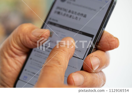 一位日本老人的指尖粗大，操作智慧型手機有困難 112916554