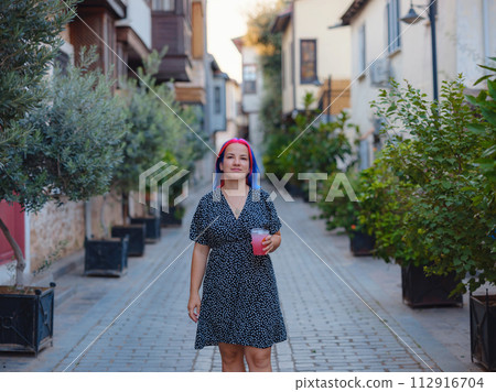 female summer old town walk in Antalya Turkey. Woman with colorful hair and dress strolls through enchanting old town of Antalya , vibrant fusion of fashion and history female summer old town walk in Antalya Turkey. Woman with colorful hair and dress strolls through enchanting old town of Antalya , vibrant fusion of fashion and history 112916704