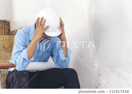 Asian young engineer man stress and failure in architecture project sitting at office on construction site. Upset despair civil construction engineer working on laptop with stressed problems Asian young engineer man stress and failure in architecture project sitting at office on construction site. Upset despair civil construction engineer working on laptop with stressed problems 112917458