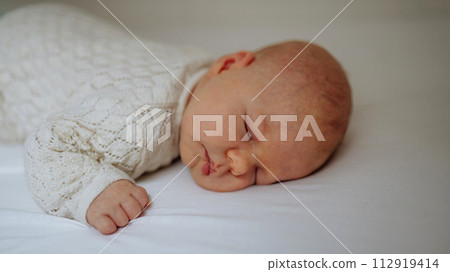 Portrait of cute little baby sleeping in bed, on belly, closed eyes. Portrait of cute little baby sleeping in bed, on belly, closed eyes. 112919414