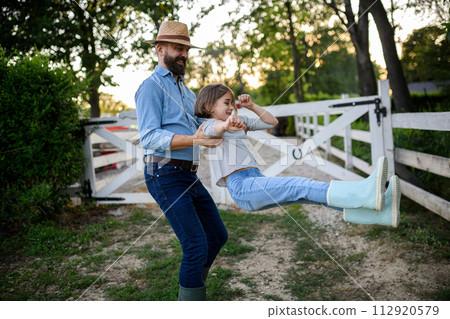 Father and young daughter having fun on family farm, farmer family. Concept of multigenerational farming. 112920579