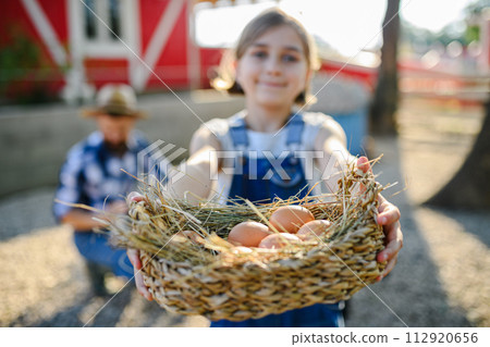Beautiful young girl helping on family farm during summer, holding lavender plant in pot. Beautiful young girl helping on family farm during summer, holding lavender plant in pot. 112920656