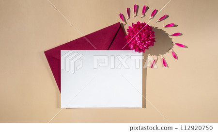 Beautiful little pink flowers on postal red envelope on beige background, empty paper note copy space for text, spring time, greeting card for holiday. Flower delivery Beautiful little pink flowers on postal red envelope on beige background, empty paper note copy space for text, spring time, greeting card for holiday. Flower delivery 112920750